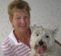 Lady holding her white westie dog in her arms