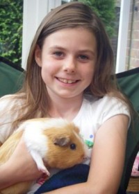 Girl holding guinea pig in her arms